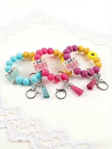 Detail view of colorful silicone bead wristlet keychains with sunflowers and tassels.