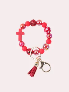 Red silicone beaded bracelet keychain featuring a cross charm and handmade suede tassel