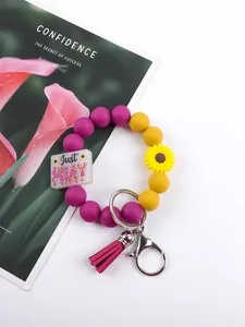 Silicone bead wristlet keychain featuring yellow sunflower, purple tassel, and 'Just Pray' charm