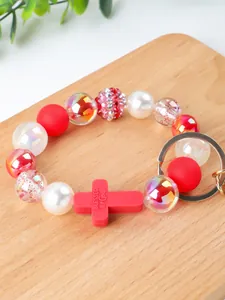 Close-up of silicone beaded keychain with red cross pendant and 'Blessed by God' text
