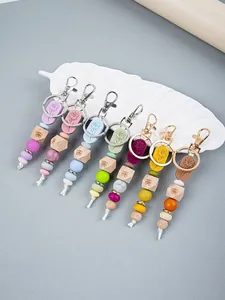 Variety of handmade rose and butterfly beaded keychains displayed on a white leaf tray
