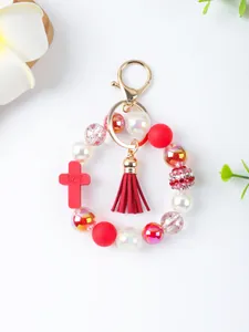 Detailed view of handmade beaded keychain with red silicone cross and tassel charm