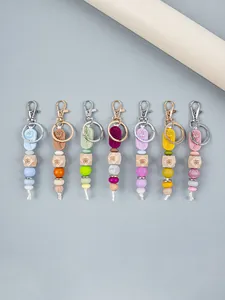 Detail showing a variety of colorful silicone and wooden bead keychains with rose tags.