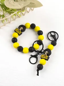 Detail of yellow and black silicone bead keychain with 'God Is My Strength' charm