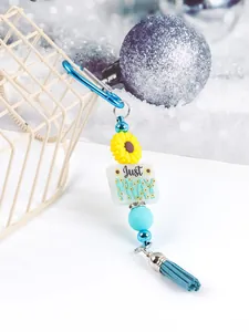 Close-up of sunflower silicone bead keychain with Just PRAY message and blue tassel