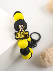 Close-up of yellow and black silicone bead keychain with God Is My Strength PVC charm.