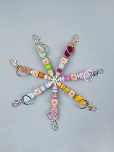 Detailed view of colorful silicone and wooden beaded keychains with rose charms in radial layout