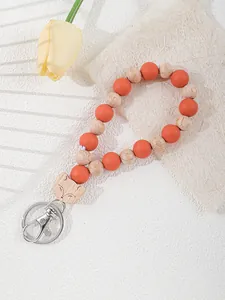 Macro detail of silicone and wood beaded keychain featuring a laser-engraved cat charm.