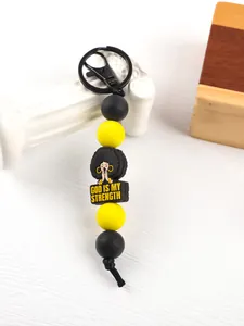 Detailed view of handmade silicone bead keychain featuring a 'God Is My Strength' charm