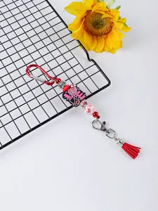 Detalle del llavero de cuentas de silicona con dije LOVE y una borla roja brillante