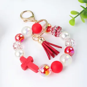 Red and white handmade silicone beaded keychain with cross charm and red suede tassel
