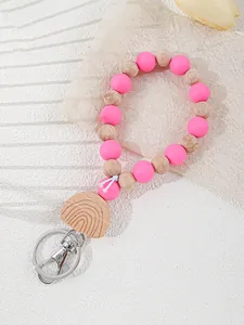 Detail view of silicone and wooden beaded keychain with rainbow engraved charm