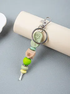 Detailed view of silicone beads and engraved wooden bead on a rose floral keychain