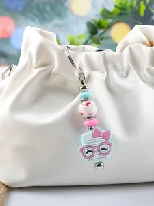 Cute silicone keychain with colorful beads and cartoon character on a stylish white bag