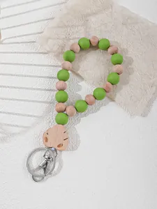 Close-up of silicone and wooden bead keychain wristlet with a laser-cut leaf charm