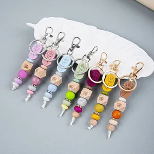 Handmade rose print silicone and wood bead keychains for women, set of seven vibrant colors.