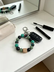 Detalle del llavero de cuentas de silicona en un tocador blanco con accesorios