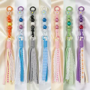 Detailed view of colorful handmade beaded tassels with lace and ribbon for bag charms.