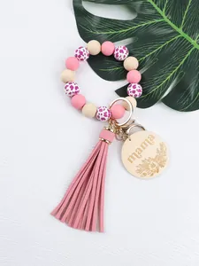 Close-up of silicone bead wristlet keychain with pink leather tassel and mama wood tag