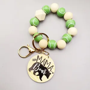 Detalle de las cuentas de tenis y el colgante de madera grabado MAMA Bear en el llavero.