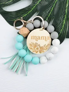 Silicone bead wristlet keychain with engraved Mama wooden disc and mint tassels.