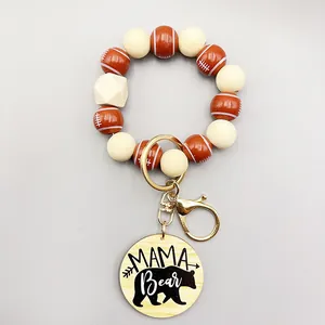 Detalle de llavero de pulsera de cuentas de madera de fútbol con colgante Mama Bear