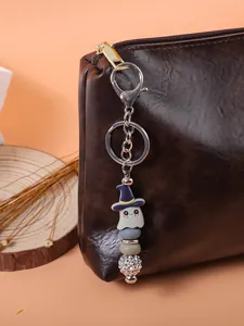 Cute Halloween ghost beaded keychain detail attached to a luxury brown leather bag zipper