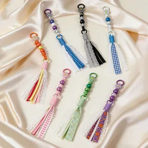 Detailed view of colorful handmade beaded tassels with lace and fabric textures for bags