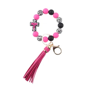 Close-up detail of silicone beaded keychain with medical cross charm and pink tassel