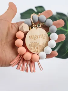 Macro view of silicone bead keychain with engraved mama wood plaque and peach tassel