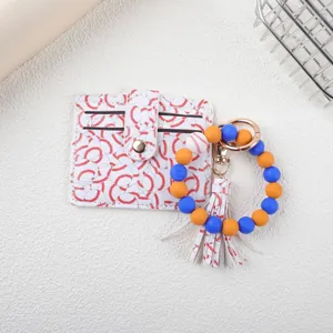 Detail view of baseball patterned cardholder with silicone bead wristlet and tassel.