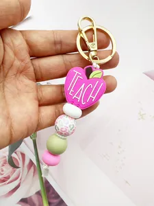 Close-up of pink apple Teach silicone bead keychain with leopard print and gold clasp