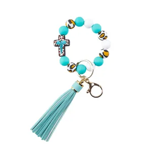 Close-up view of silicone beaded keychain with teal tassel and leopard print beads