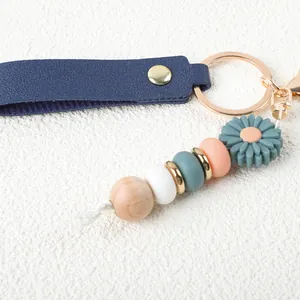 Detailansicht des blauen Lederarmbands mit Silikonperlen und Gänseblümchen-Anhänger.