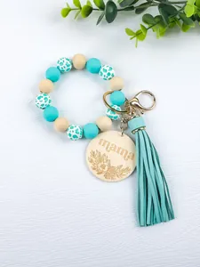 Close-up of silicone bead bracelet keychain with engraved mama wooden tag and leather tassel.