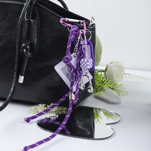 Detail of purple DIY cassette frame bag charm with headphone pendant on black bag