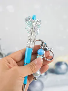 Close-up of fashion blue beaded ballpoint pen with sparkling bow and rhinestones detail