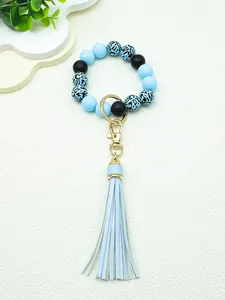Detail of light blue silicone beaded keychain with leopard print accents and tassel.