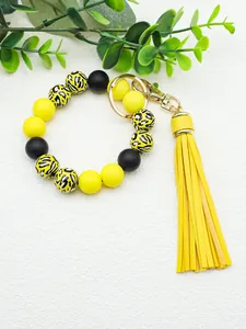 Close-up of yellow and black beaded bracelet keychain with animal print and tassel