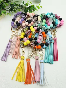 Detailed view of colorful silicone and wood bead keychains with long PU tassels.