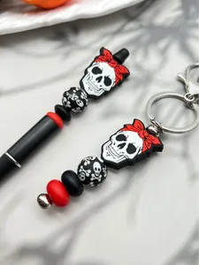 Detaillierte Nahaufnahme von Halloween-Totenkopf-Silikonperlen auf Stift und Kette.