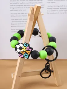 Detalle del brazalete de cuentas de silicona con tema de fútbol y colgante
