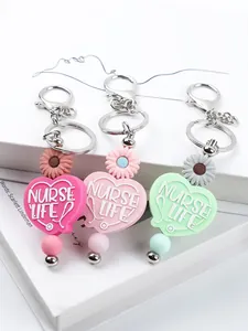 Close-up of cute nurse life silicone heart keychains with daisy beads in multiple colors
