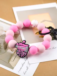 Detalle de pulsera de cuentas de silicona rosa con amuleto cheer y cierre negro