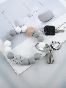 Close-up detail of silicone beaded wristlet keychain with grey tassel and hexagon wooden bead