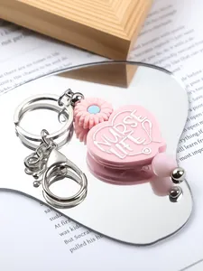 Detailed view of pink heart silicone keychain with NURSE LIFE text and daisy bead detail