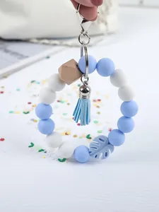 Detail view of a blue and white silicone bead wristlet keychain with a soft tassel