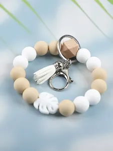 Close-up of the handcrafted silicone beads and white tassel on this wristlet keychain