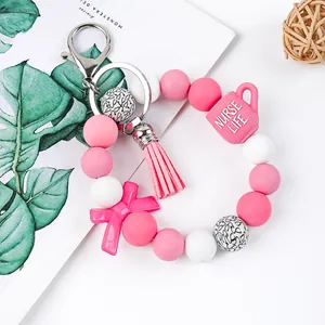Detail of a pink silicone beaded nurse keychain with a "Nurse Life" cup charm.