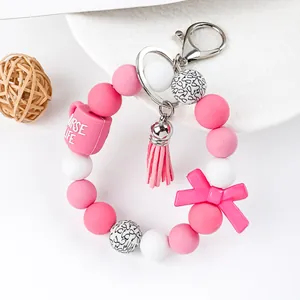 Close-up of nurse-themed silicone beaded keychain with pink tassel and bow detail